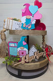 Decorative tiered tray with Valentine's Day-themed items including gnomes and heart-shaped balloons.